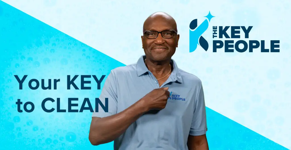 Commercial Cleaner pointing to the Key People logo on his shirt. Your Key to Clean